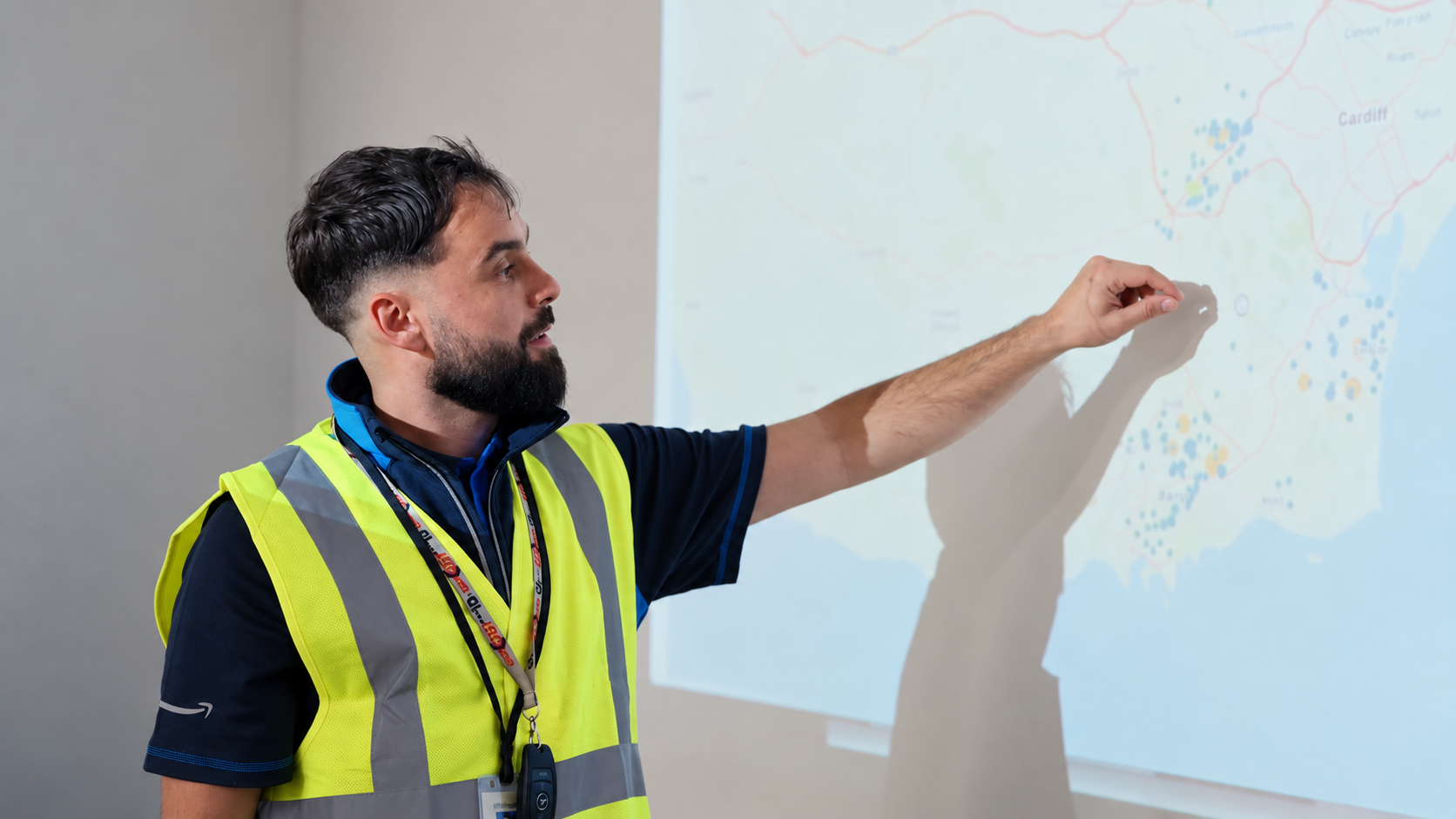 A team member explaining a delivery area on a projected map